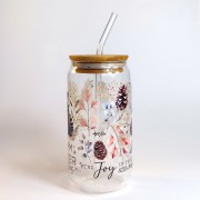 Szklany kubek 550 ml z bambusową pokrywką i szklaną słomką - szop w zimowym anturażu z gałązek iglastych, szyszek, śnieżek i z dopiskiem "Warm winter" - ciepła zima - pocichutku.pl