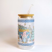 Szklany kubek 550 ml z bambusową pokrywką i szklaną słomką - skrzaty, a za nimi samochód z choinką na tylnej pace, całość zachowana głównie w pastelowym błękitnym kolorze - pocichutku.pl