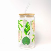 Szklany kubek 550 ml z bambusową pokrywką i słomką - monstera i inne zielone liście okazałych roślin w żywych, jasnych kolorach - pocichutku.pl