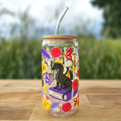 Szklany kubek 550 ml z bambusową pokrywką i szklaną słomką - smok siedzący na książce, wokół motywy z fantastyki i romansu - pocichutku.pl
