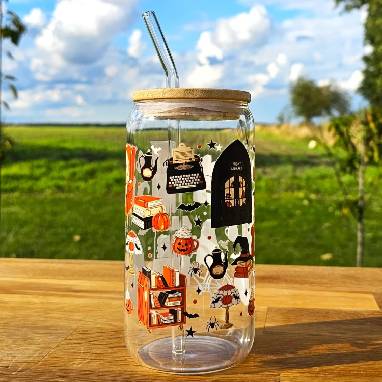 Szklany kubek 550  ml z pokrywką i słomką - Night Library z duszkiem, pomarańczowymi i czarnymi elementami - pocichutku.pl